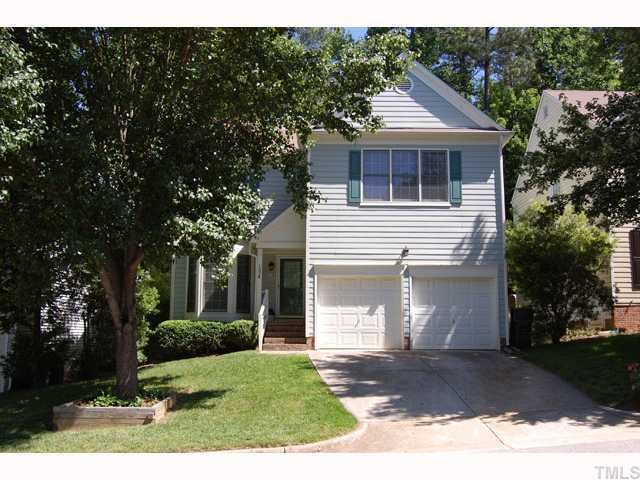 134 Solstice Circle Cary, NC 27513 - Photo 1 of 12 a front view of a house with a garden and trees