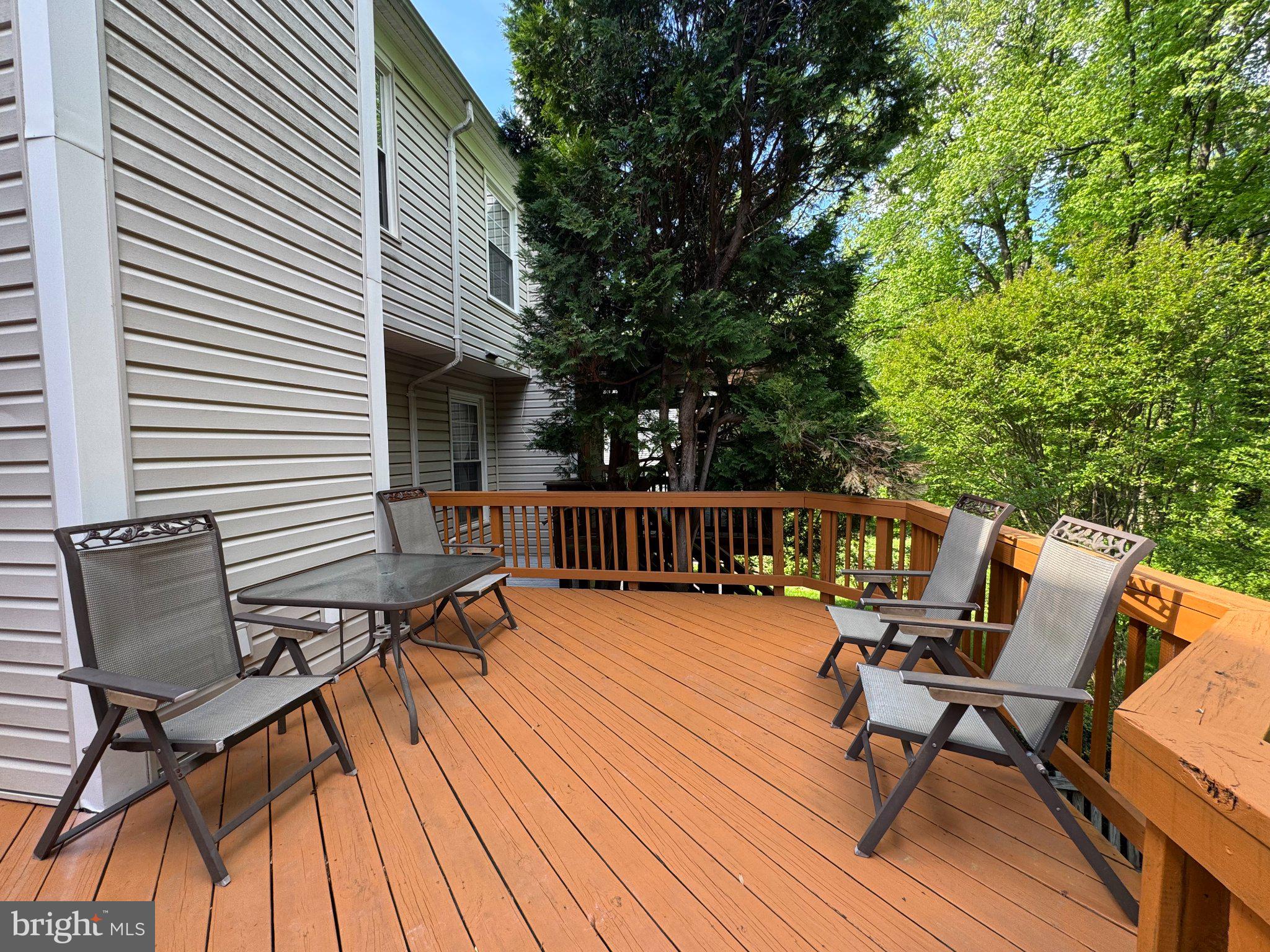 10542 Reed's Landing Circle Burke, VA 22015 - Photo 26 of 32 a balcony with wooden floor outdoor seating and trees