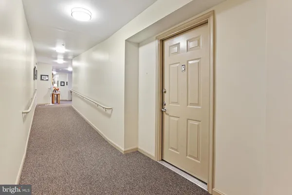 a view of a hallway with wooden floor and a livingroom