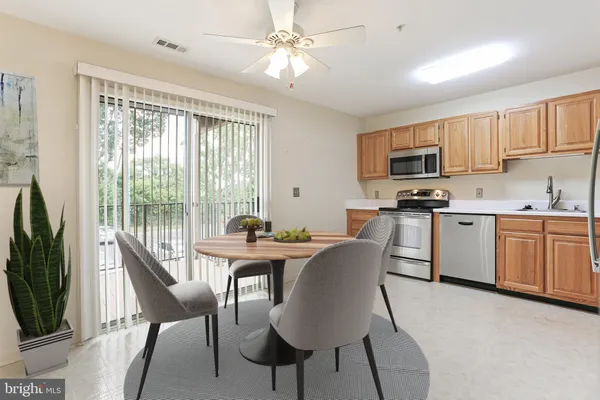 a kitchen with stainless steel appliances granite countertop a refrigerator a stove top oven a sink dishwasher and wooden cabinets
