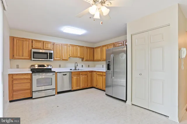 a kitchen with cabinets stainless steel appliances and a window