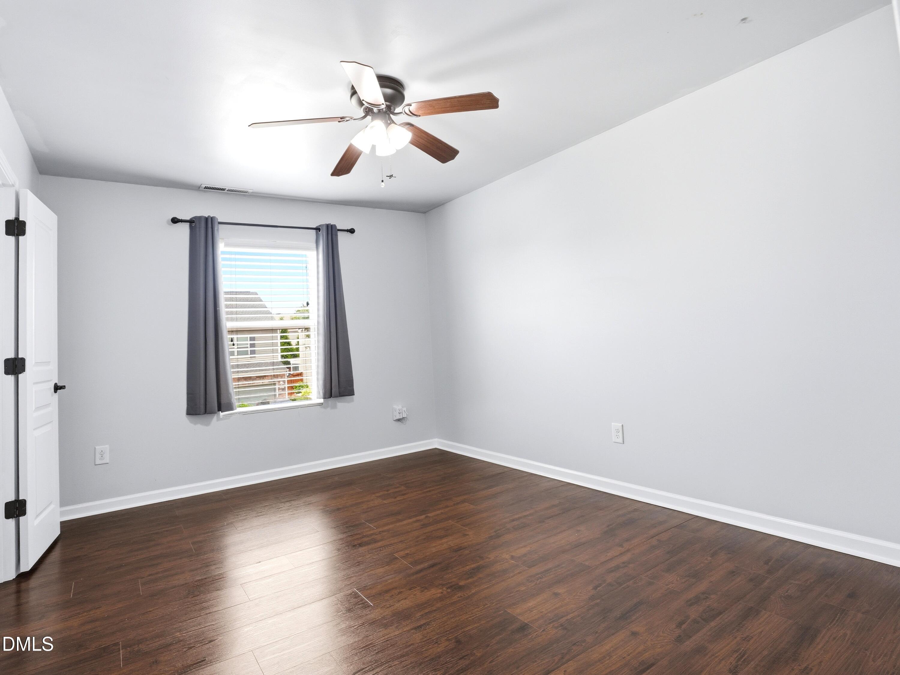 8128 Hovingham Way Raleigh, NC 27616 - Photo 24 of 40 an empty room with wooden floor chandelier fan and windows