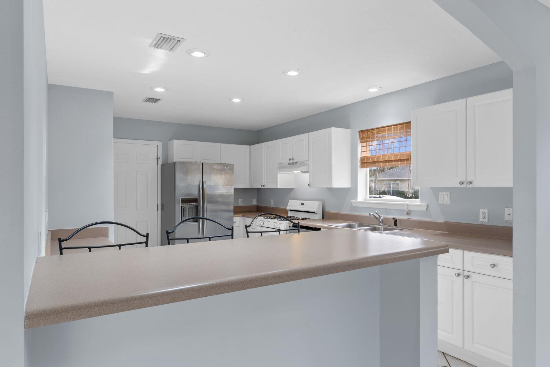 120 Hibiscus Lane Miramar Beach, FL 32550 - Photo 17 of 57 a kitchen with stainless steel appliances granite countertop a sink a stove and a refrigerator