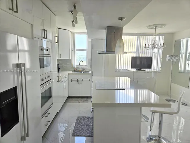 a kitchen with stainless steel appliances a refrigerator sink and microwave