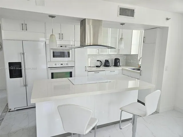 a kitchen with stainless steel appliances a refrigerator stove microwave and white cabinets