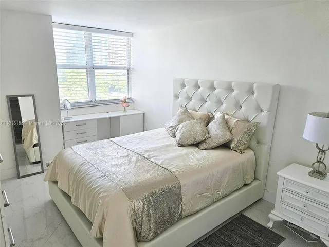 a large bed sitting in a bedroom next to a window