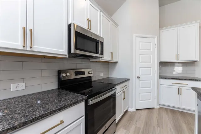 a kitchen with stainless steel appliances granite countertop a sink and a stove