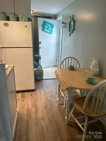 a white kitchen with a table and a refrigerator