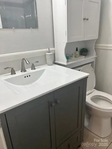 a bathroom with a sink toilet and a mirror