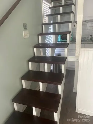a view of a hallway with wooden floor and a cabinet