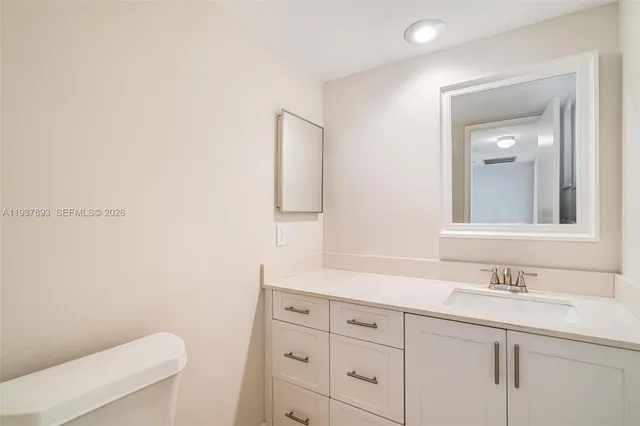 a bathroom with a sink a toilet a mirror and vanity