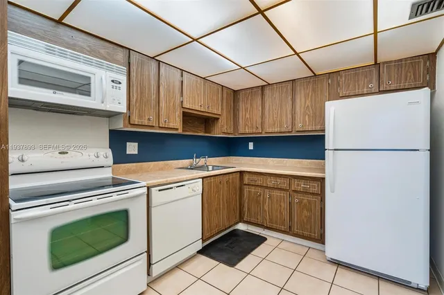a kitchen with a sink a refrigerator and cabinets