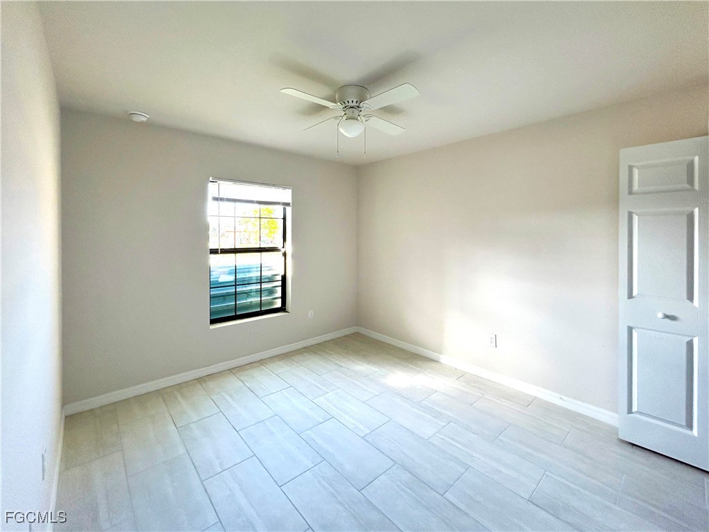3608 Southwest 17th Avenue Cape Coral, FL 33914 - Photo 3 of 10 an empty room with wooden floor and windows