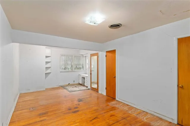 a room with a wooden floor and a window