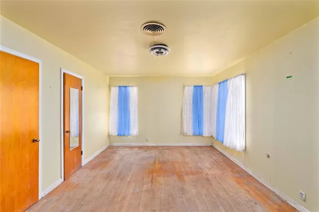 an empty room with closet and wooden floor