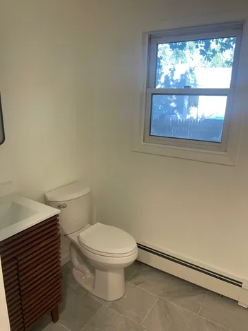 a white toilet sitting next to a window