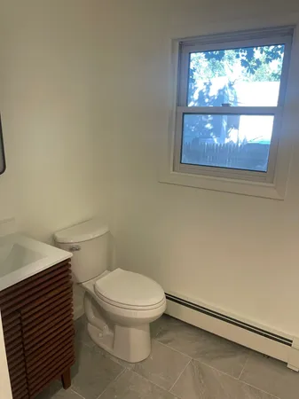 a white toilet sitting next to a window