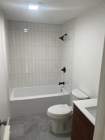 a bathroom with a toilet and a bath tub