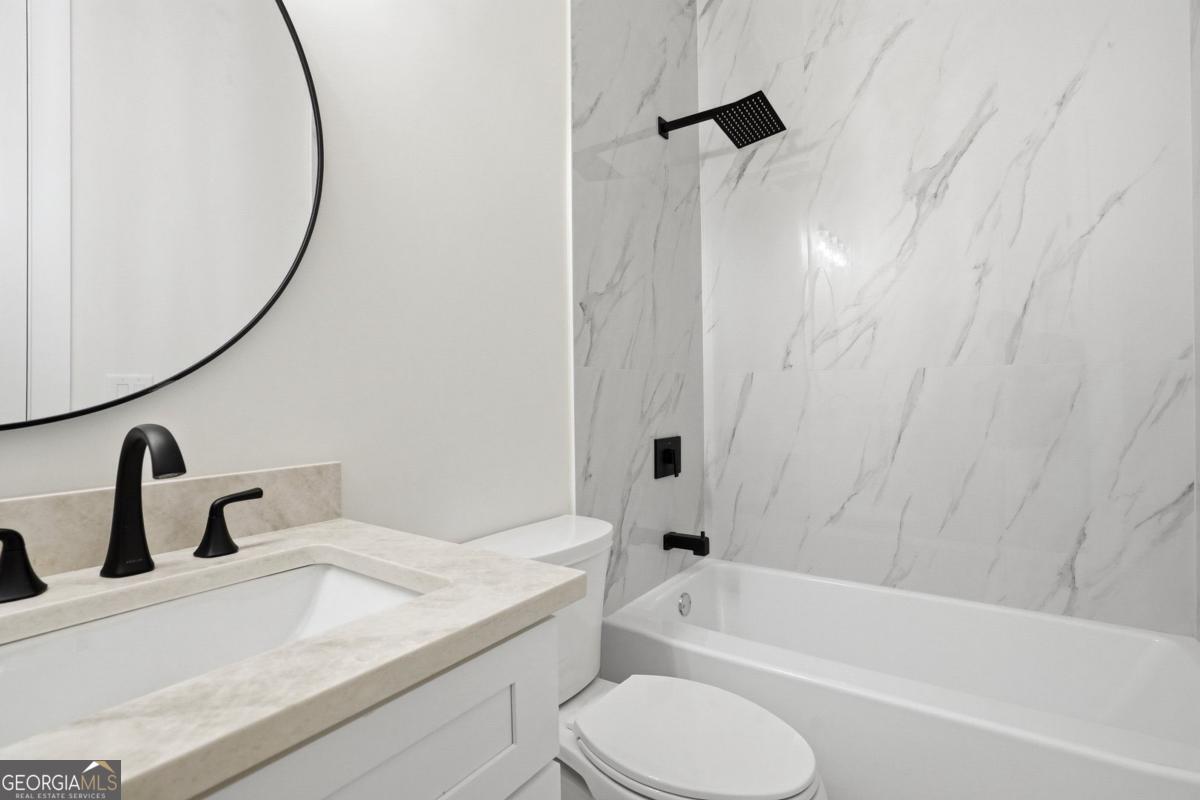 1557 Whitley Road Dacula, GA 30019 - Photo 34 of 46 a bathroom with a granite countertop sink toilet and bathtub