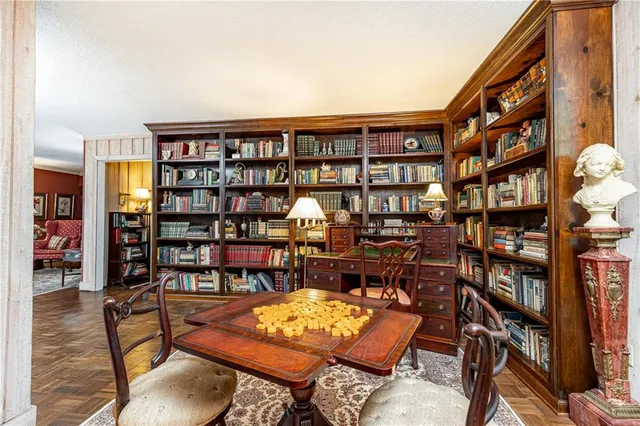 a living room with furniture a rug and a book shelf