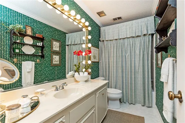 a bathroom with a sink vanity mirror and toilet