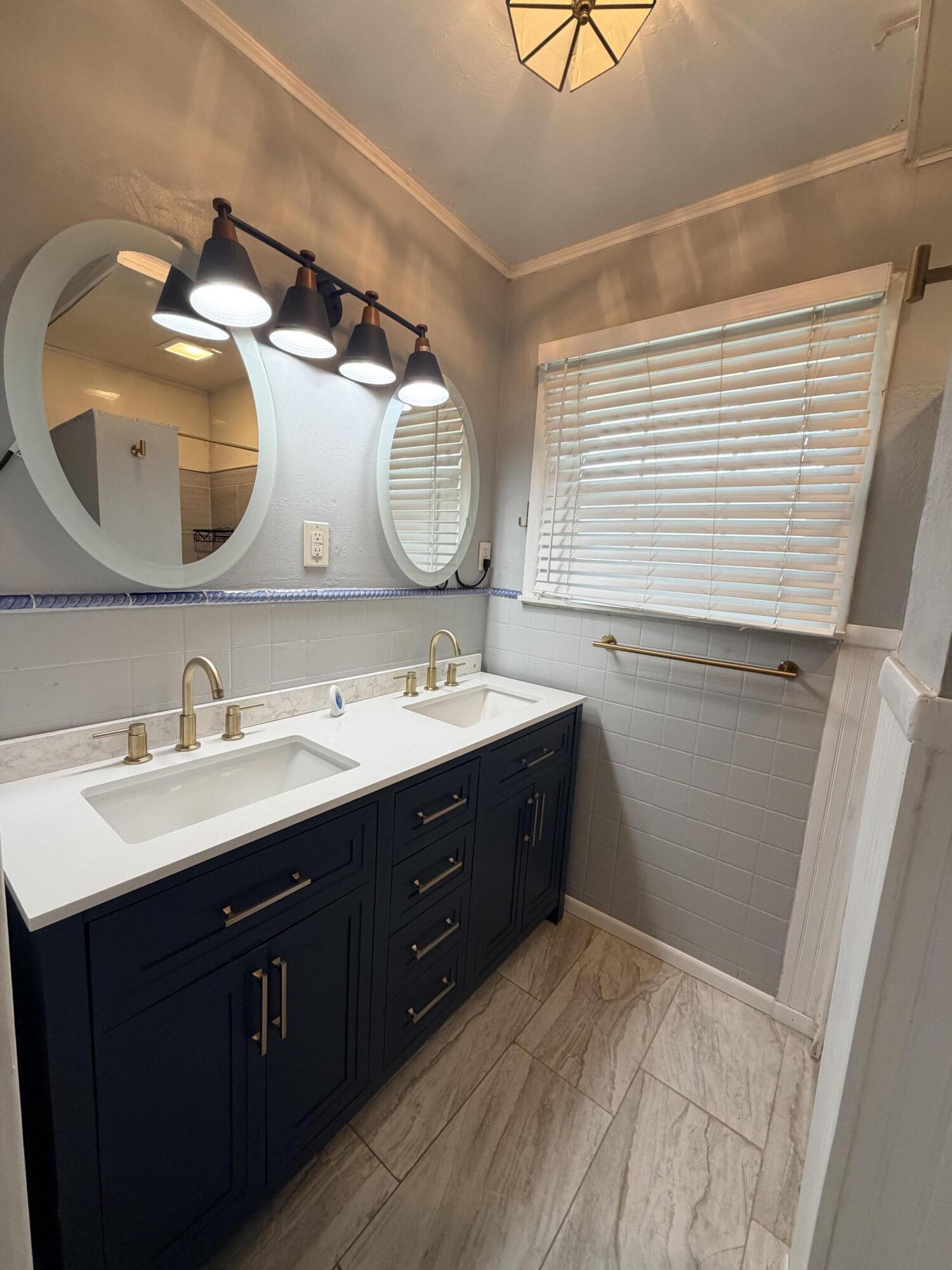3814 27th Street Lubbock, TX 79410 - Photo 14 of 24 a bathroom with a double vanity sink and a mirror
