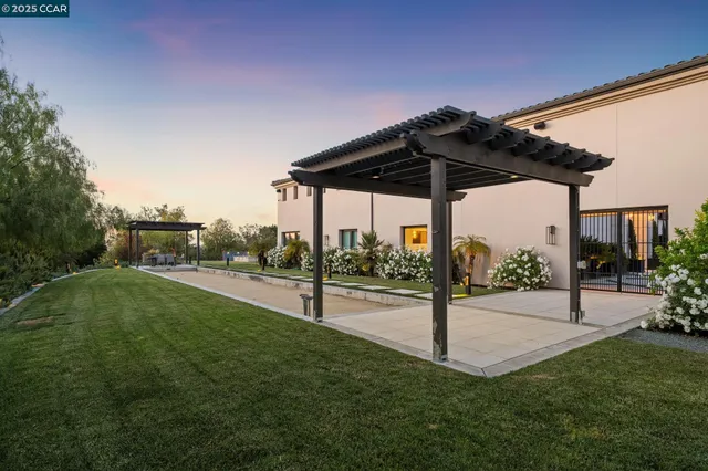 a large white kitchen with stainless steel appliances kitchen island granite countertop a refrigerator and stove