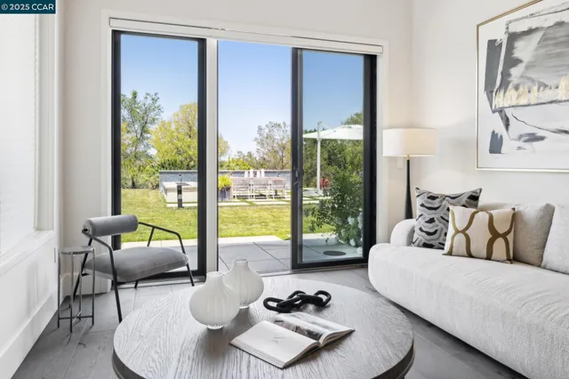 a living room with furniture a bookshelf and a window