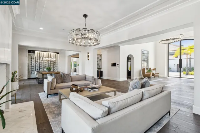 a living room with lots of furniture and view of kitchen