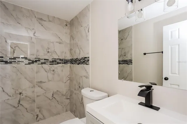 a bathroom with a sink toilet and shower