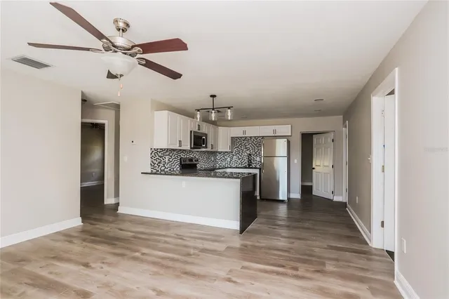 a kitchen with stainless steel appliances kitchen island a refrigerator sink and cabinets
