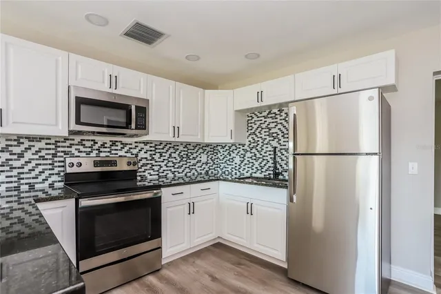 a kitchen with a refrigerator stove and microwave