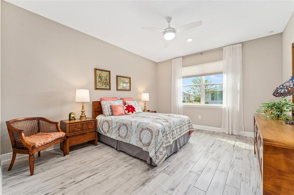 8290 Southwest 92nd Circle Ocala, FL 34481 - Photo 27 of 46 a bedroom with a large bed and a chair