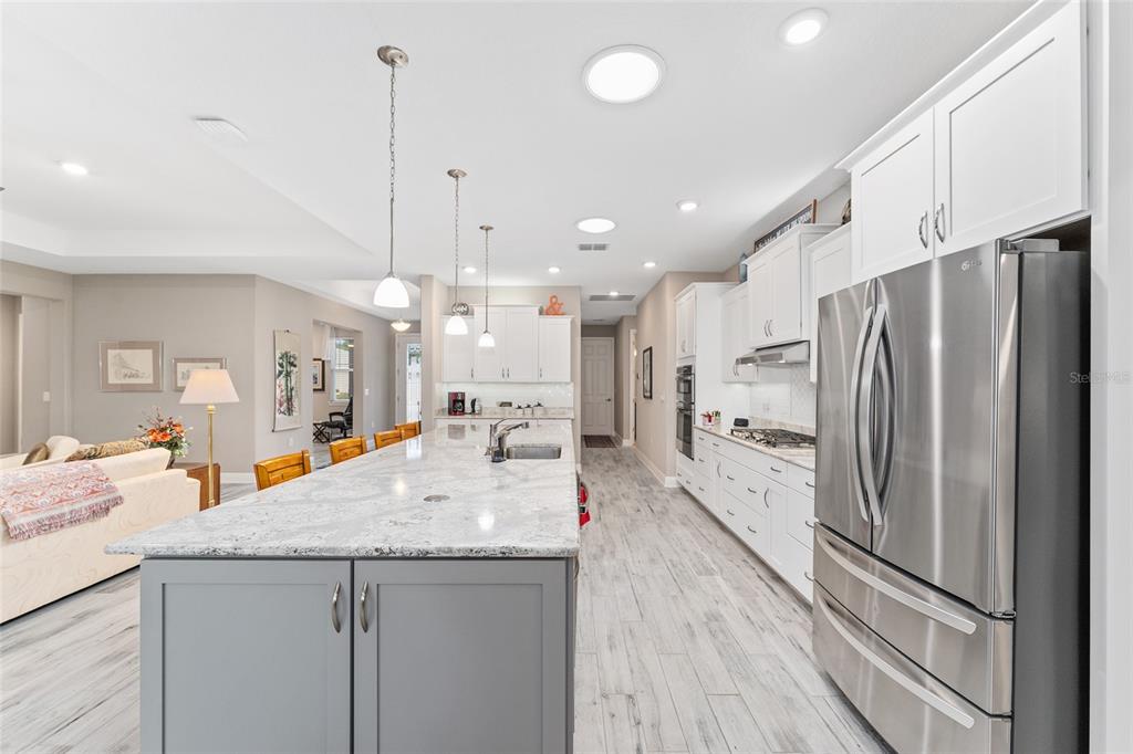 8290 Southwest 92nd Circle Ocala, FL 34481 - Photo 7 of 46 a kitchen with stainless steel appliances kitchen island granite countertop a refrigerator a oven and a sink with large cabinets