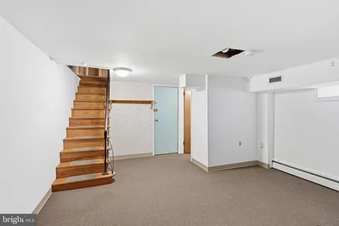 a view of an empty room with stairs and ventilation