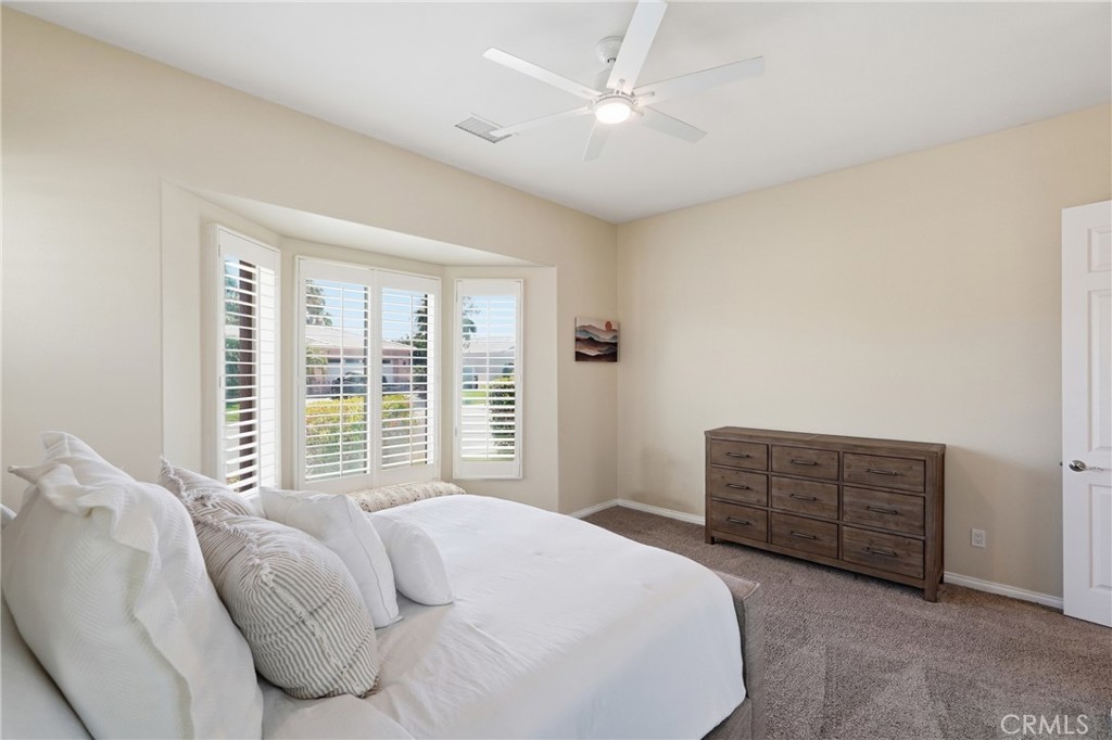 9 Orleans Road Rancho Mirage, CA 92270 - Photo 37 of 71 a bedroom with a bed a dresser and a window