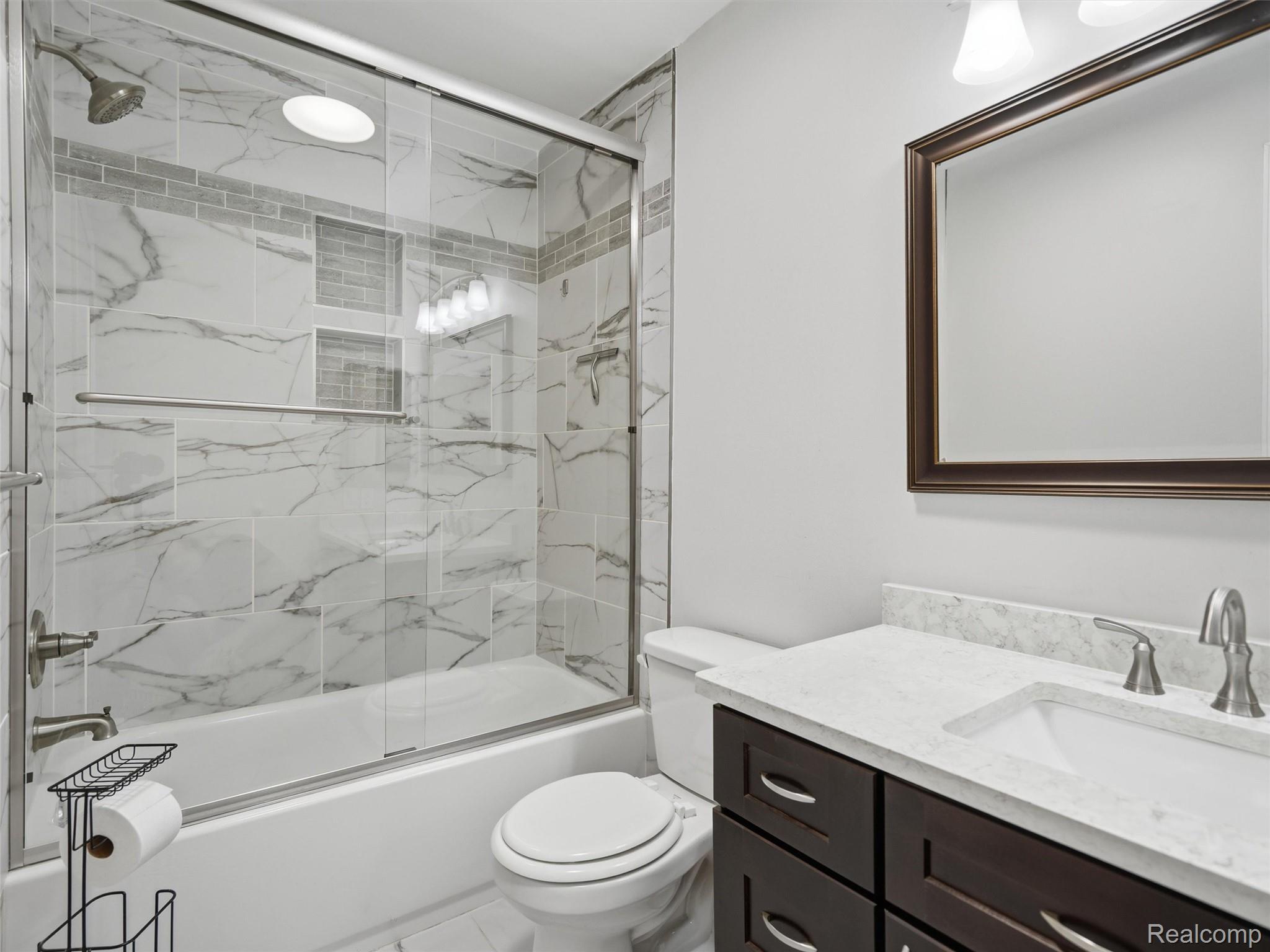 29636 Middlebelt Road, Unit 2602 Farmington, MI 48334 - Photo 19 of 34 Spa-inspired primary bathroom featuring a frameless glass-enclosed shower with marble subway tile surround, dual showerheads, and a white subway tile accent wall