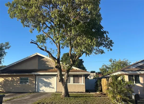 a front view of a house with a tree