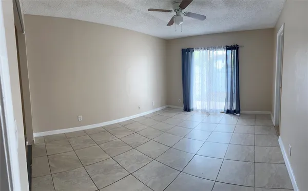 an empty room with a ceiling fan and carpet