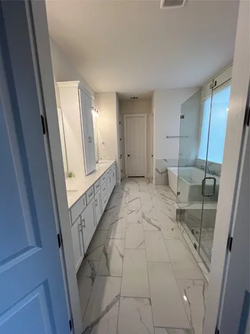 a bathroom with a tub sink and mirror