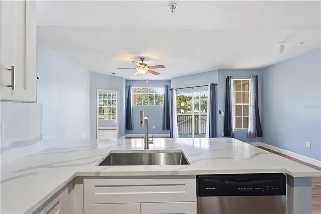 wooden floor in an empty room with a chandelier fan