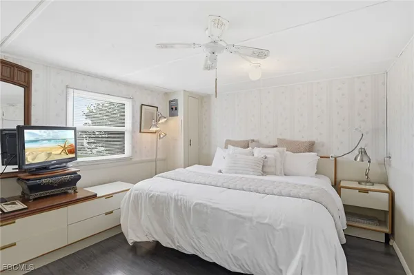 a bedroom with a bed and a flat tv screen on the dresser