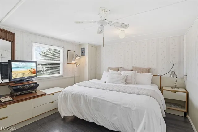 a bedroom with a bed and a flat tv screen on the dresser