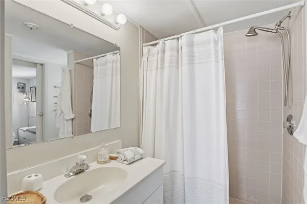 a bathroom with a sink a mirror and a shower curtain