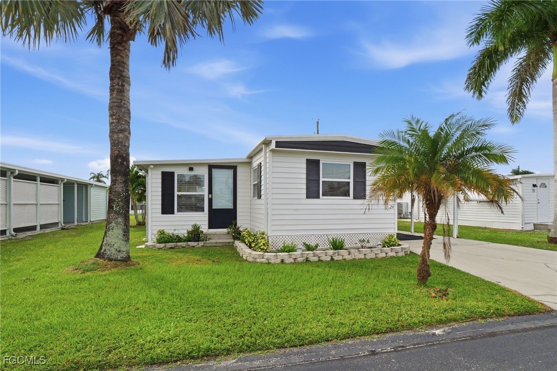 24 Cheyenne Trail, Unit 167 Naples, FL 34113 - Photo 2 of 27 a front view of house with yard and entertaining space