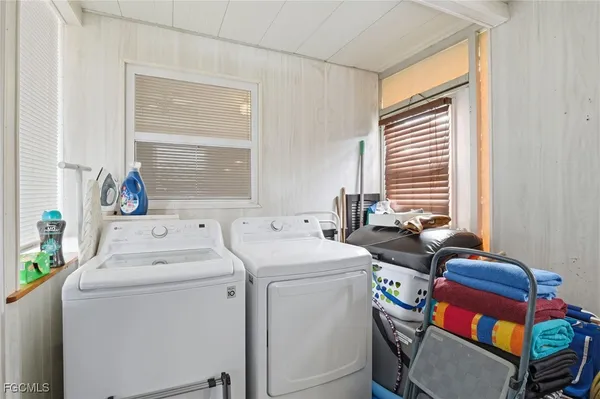 a view of washer and dryer with bathroom in the background