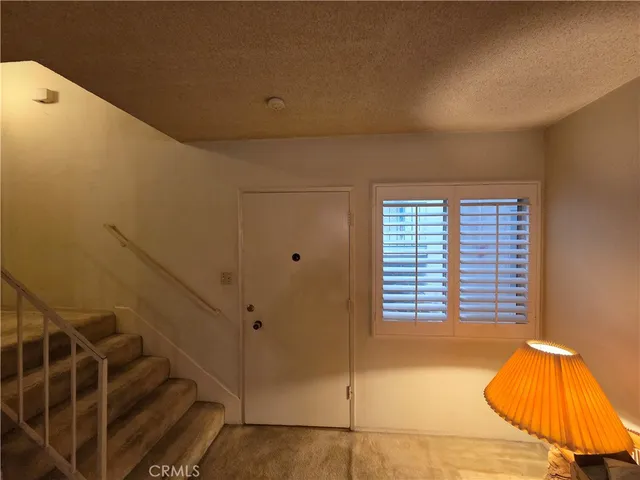 a view of staircase with white walls and a window