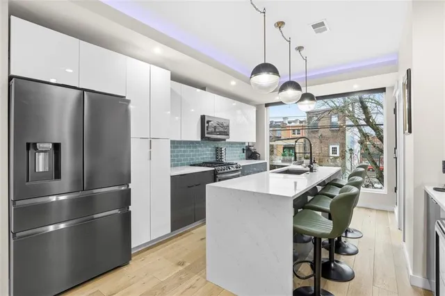 a kitchen with kitchen island a center island and stainless steel appliances