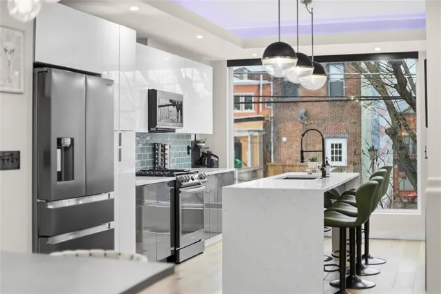 a kitchen with stainless steel appliances granite countertop a sink a stove and a refrigerator