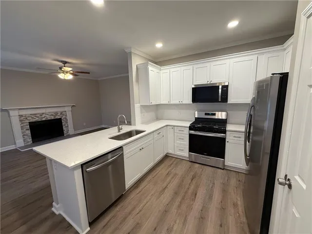 a view of an empty room with wooden floor and window